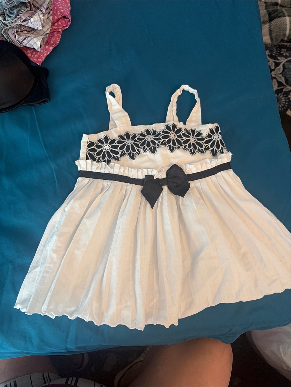 White babydoll dress with black floral lace trim and black bow
